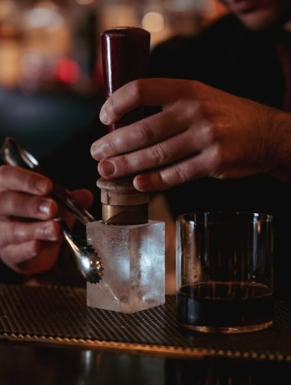 Classic cocktail lounge at Bar 1806 Melbourne with red velvet seating, dim lighting, and bartenders preparing drinks