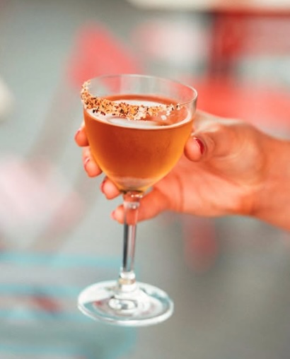 Rooftop view at Naked for Satan in Fitzroy featuring city skyline, outdoor seating, and colourful cocktails on the table