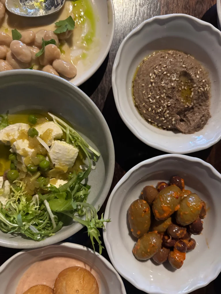 Maltese Feast dishes include fish, olives, dip, donuts at Maha East